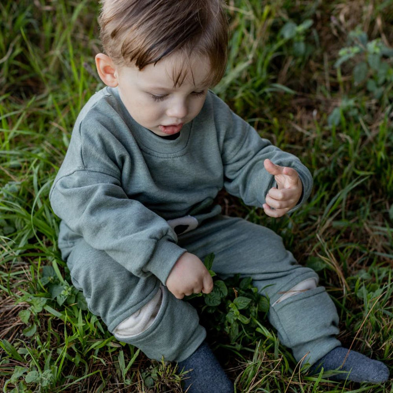 The Khaki Bear Tracksuit is not just an ordinary one. It has been designed with comfort, style and play time in mind. Front pocket has bear face detail, and the legs has soft cushion openings which provides extra cushioning when little one is crawling or sitting.

Colour - Khaki Melange