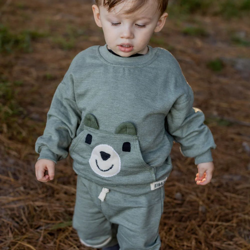 The Khaki Bear Tracksuit is not just an ordinary one. It has been designed with comfort, style and play time in mind. Front pocket has bear face detail, and the legs has soft cushion openings which provides extra cushioning when little one is crawling or sitting.

Colour - Khaki Melange