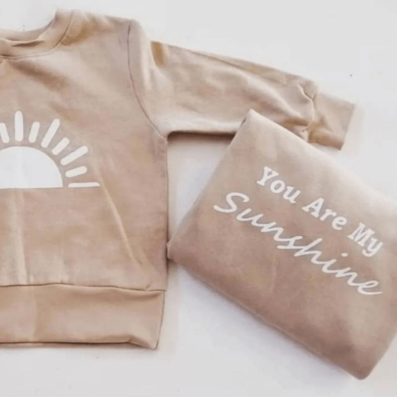 Our Sunshine Duo set has everything you need with the Matchy Look and comfort.
Round crew Neck, Rib Cuff and Waistband.
Relaxed Fit.
Stone with white print. Sunshine print on baby/toddler sweater and Mom's sweater says You are my Sunshine.
100% Cotton Brushed Fleece