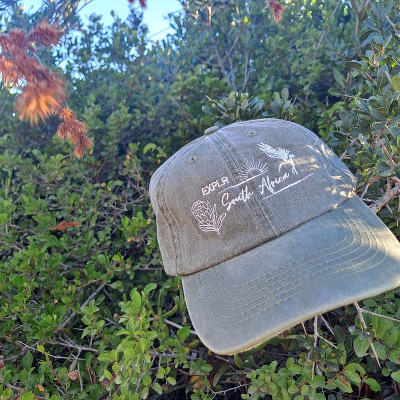 Our 1-Colour Cap brings effortless style and comfort to every adventure. Made from soft, washed cotton, it has that perfect lived-in feel from the very first wear. The classic unstructured fit and adjustable strap make it a versatile go-to for any outing—whether you're chasing sunsets, strolling along the coast, or braaing with friends. Choose your preferred logo of your go-to South African destination along with your preferred colour.