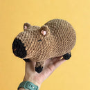 An adorable capybara with a little carrot.