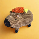 An adorable capybara with a little carrot.