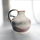 Handcrafted ceramic vase featuring a unique blend of lilac, grey, brown, and teal glaze tones.