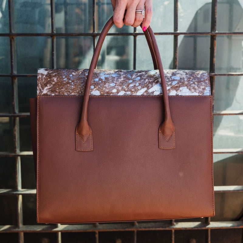 Introducing the&nbsp;Exotic Nguni Bossbag, a work bag designed for women by women. Crafted from&nbsp;rich brown leather&nbsp;and featuring an&nbsp;exotic Nguni hair-on leather finish&nbsp;with a stunning blue metallic element, this bag is both stylish and functional.