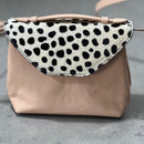 Lighter, softer and with an easy pop up handle and a detachable crossbody strap.  Meet the all new Brunch Bag.  Fully lined with custom lining, printed in South Africa. 100% Soft light grey leather with a silver/white sequins finish. Dimensions 23 cm (width) x 18 cm (height) 11cm (bottom) x 6cm (top)