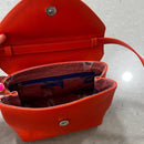 Lighter, softer and with an easy pop up handle and a detachable crossbody strap.  Meet the all new Brunch Bag.  Fully lined with custom lining, printed in South Africa. 100% Soft light grey leather with a silver/white sequins finish. Dimensions 23 cm (width) x 18 cm (height) 11cm (bottom) x 6cm (top)