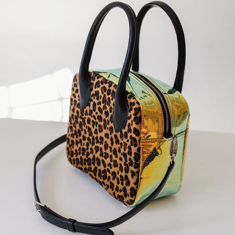 A limited-edition bag with only 10 pieces made. This exclusive design features exotic Nguni hair-on leather with delicate metallic gold splashes, beautifully complemented by a caramel leather back, bottom and sides.