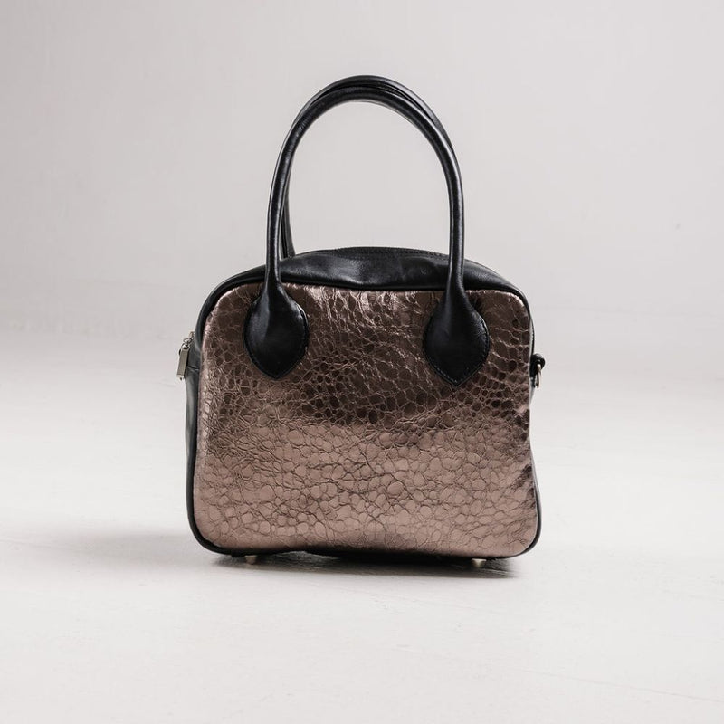 A limited-edition bag with only 10 pieces made. This exclusive design features exotic Nguni hair-on leather with delicate metallic gold splashes, beautifully complemented by a caramel leather back, bottom and sides.