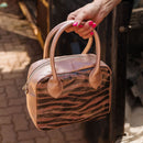 A limited-edition bag with only 10 pieces made. This exclusive design features exotic Nguni hair-on leather with delicate metallic gold splashes, beautifully complemented by a caramel leather back, bottom and sides.